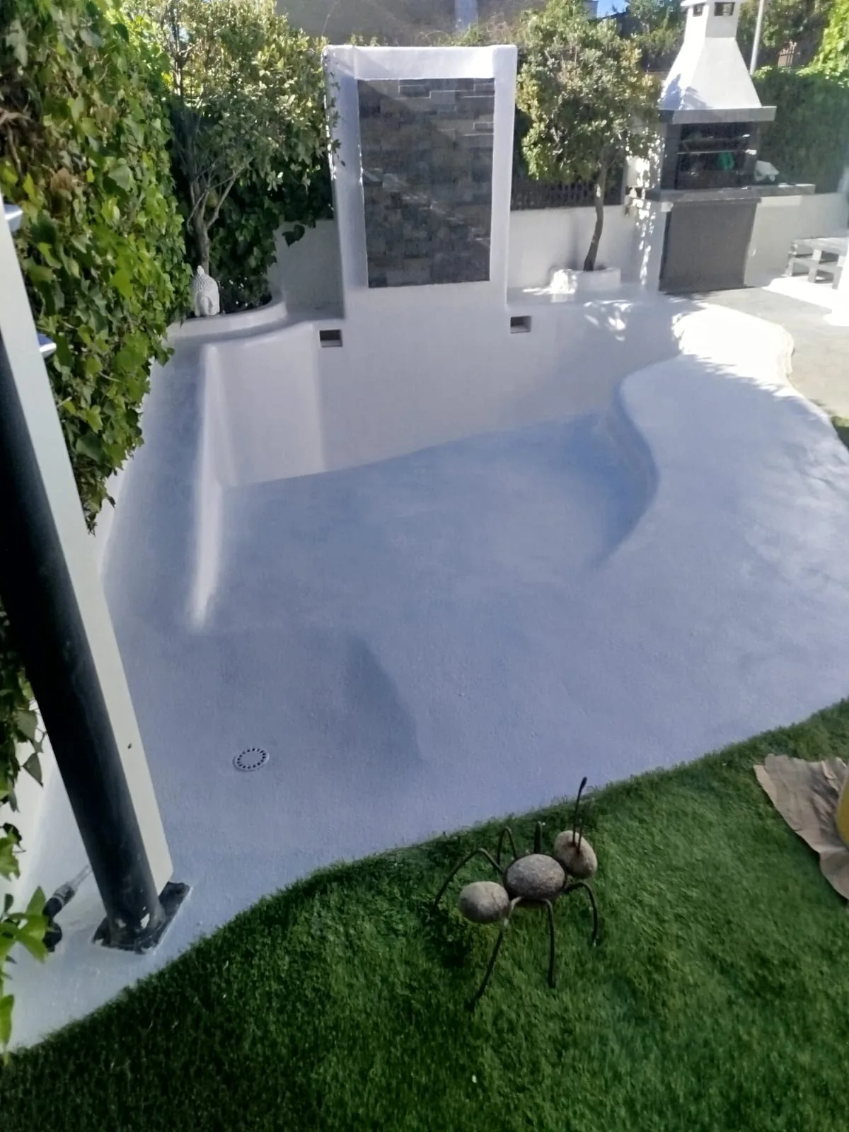Piscina de forma curva terminada tras la rehabilitación realizada por Piscinas Elite