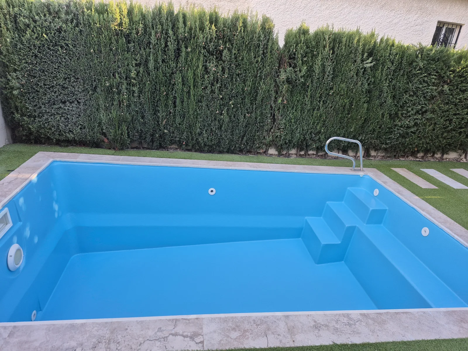 Trabajo real de Piscinas Elite: piscina rectangular rehabilitada con revestimiento azul y escalera integrada